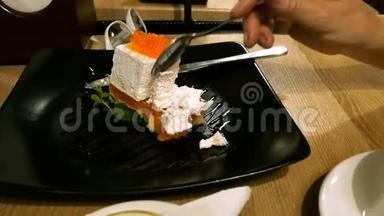 女人在咖啡馆或餐馆吃蛋糕，用勺子<strong>拿起</strong>蛋糕，喝杯子里的茶。
